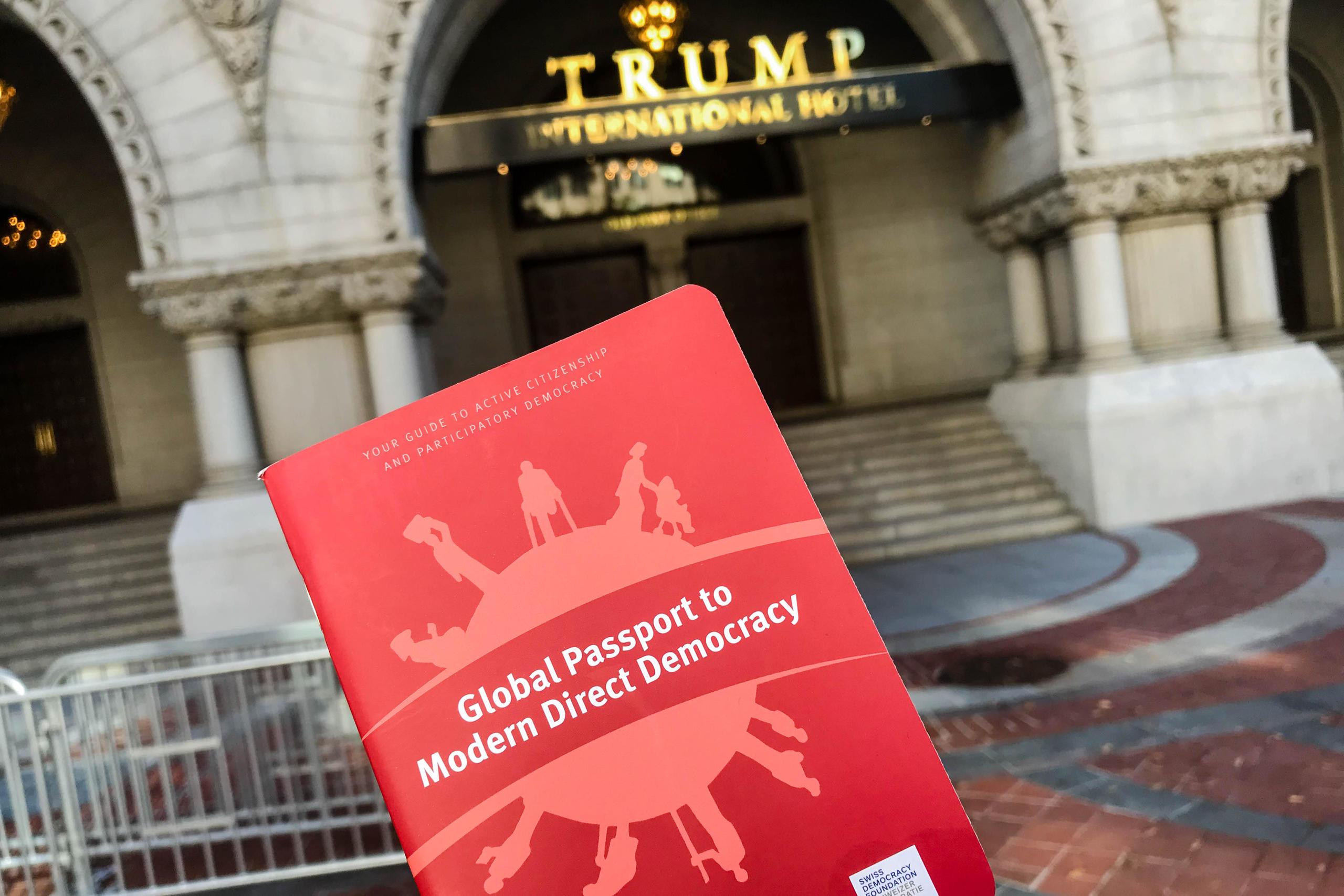 Global Passport to Modern Democracy held against the background of the Trump International Hotel