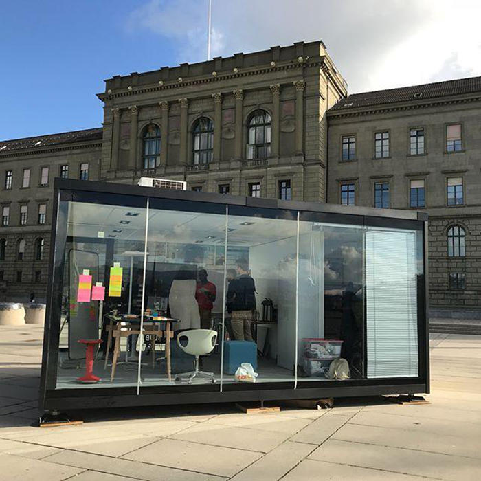 people standing inside a glass box