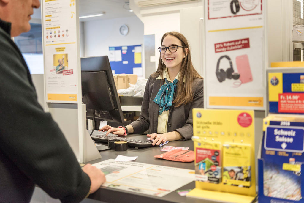 An apprentice of the Swiss Post serves a customer in Basel