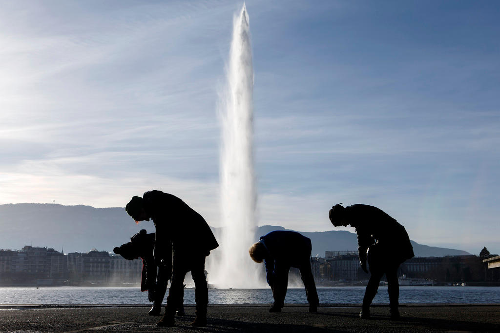 Four women do yoga in front of the famous water fountain Le Jet d Eau in Geneva