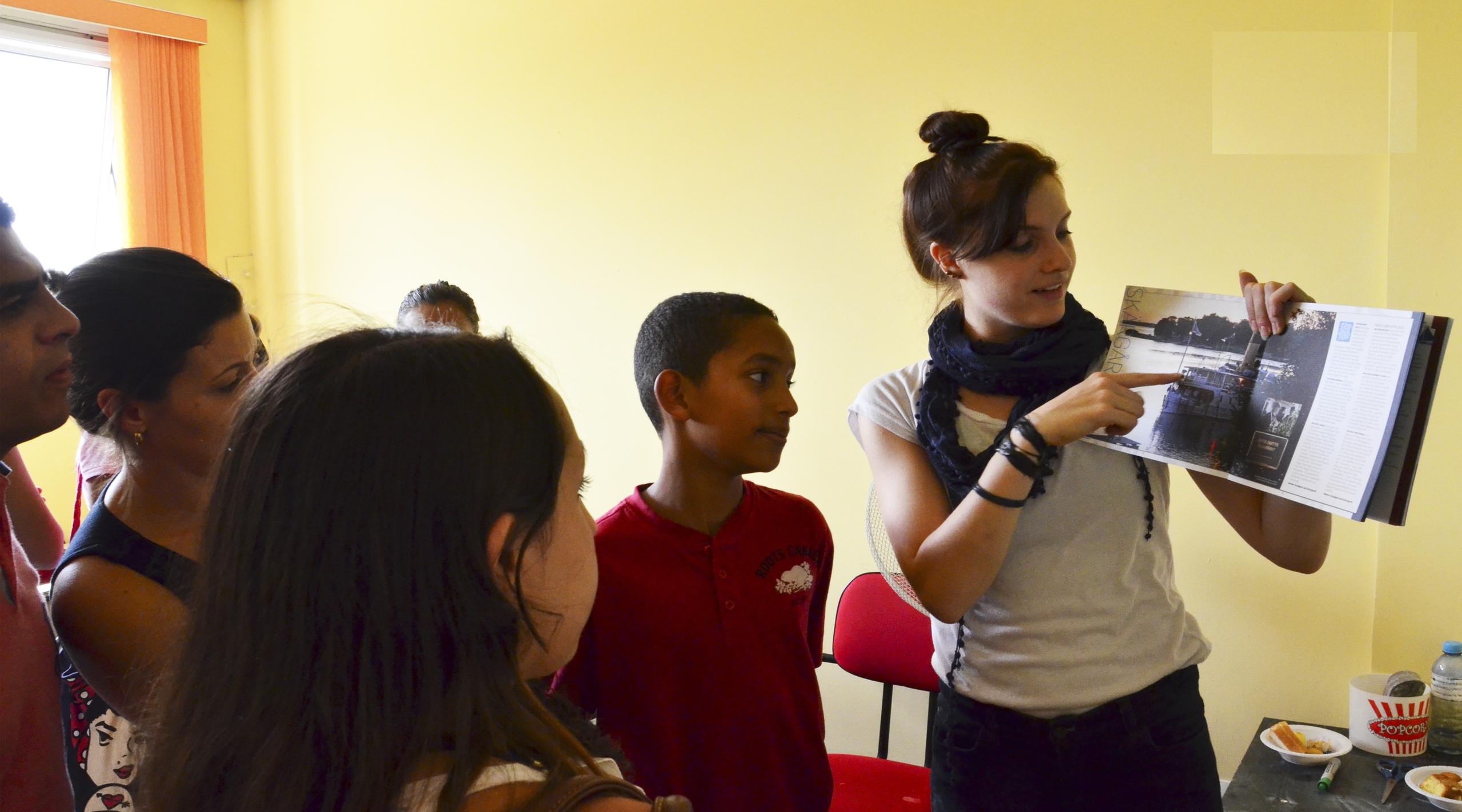 Jovem professora ensinando inglês às crianças na escola de línguas.
