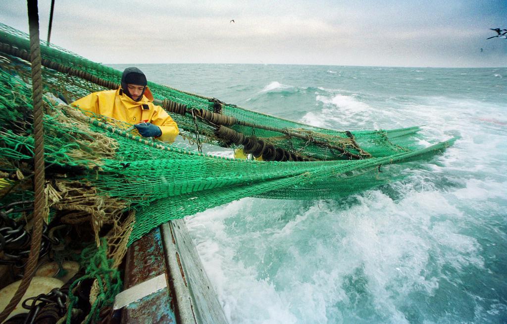 A sailor works on a fishing trawler off the French Brittany Coast in 2001
