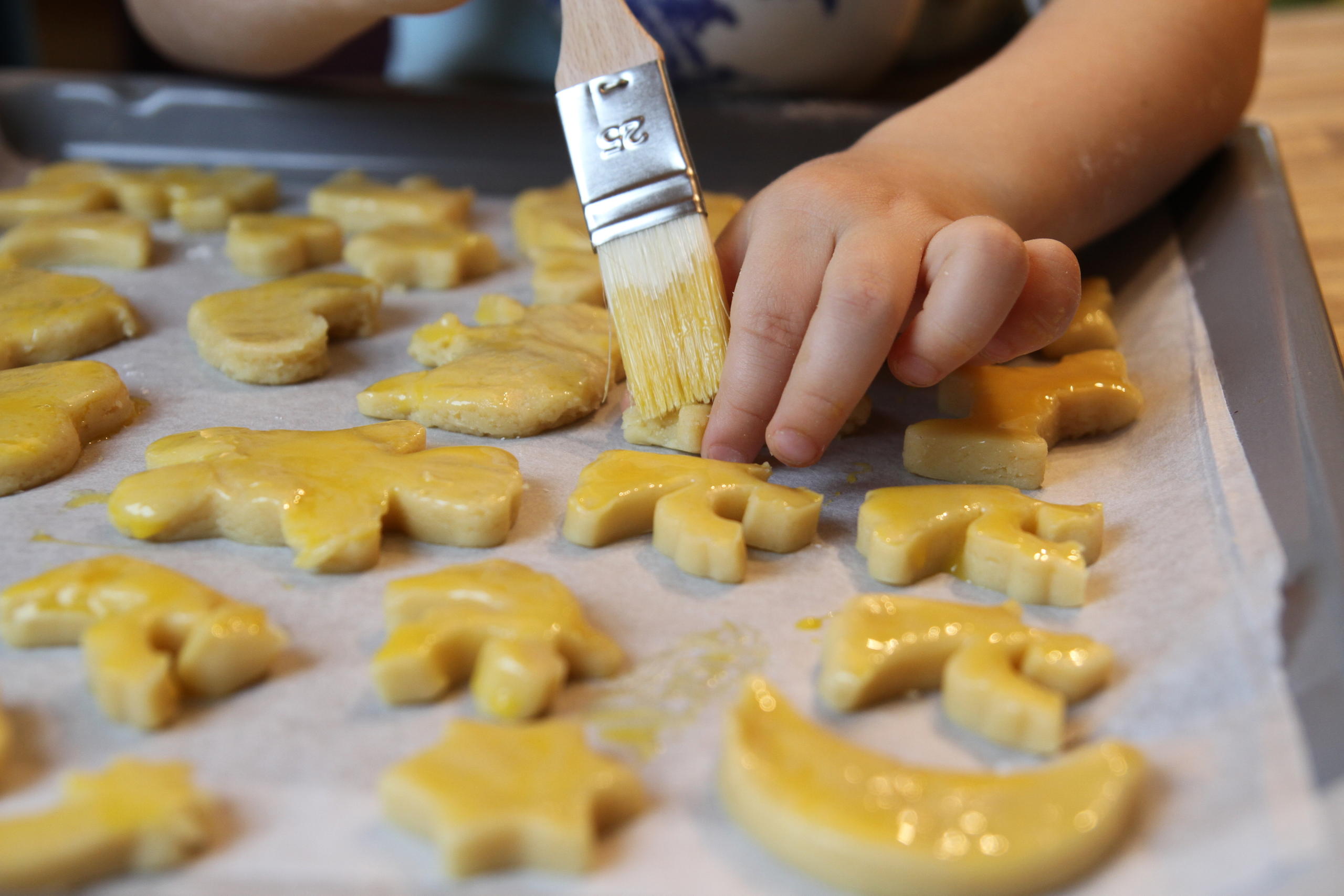 Hand putting egg yoke on biscuits