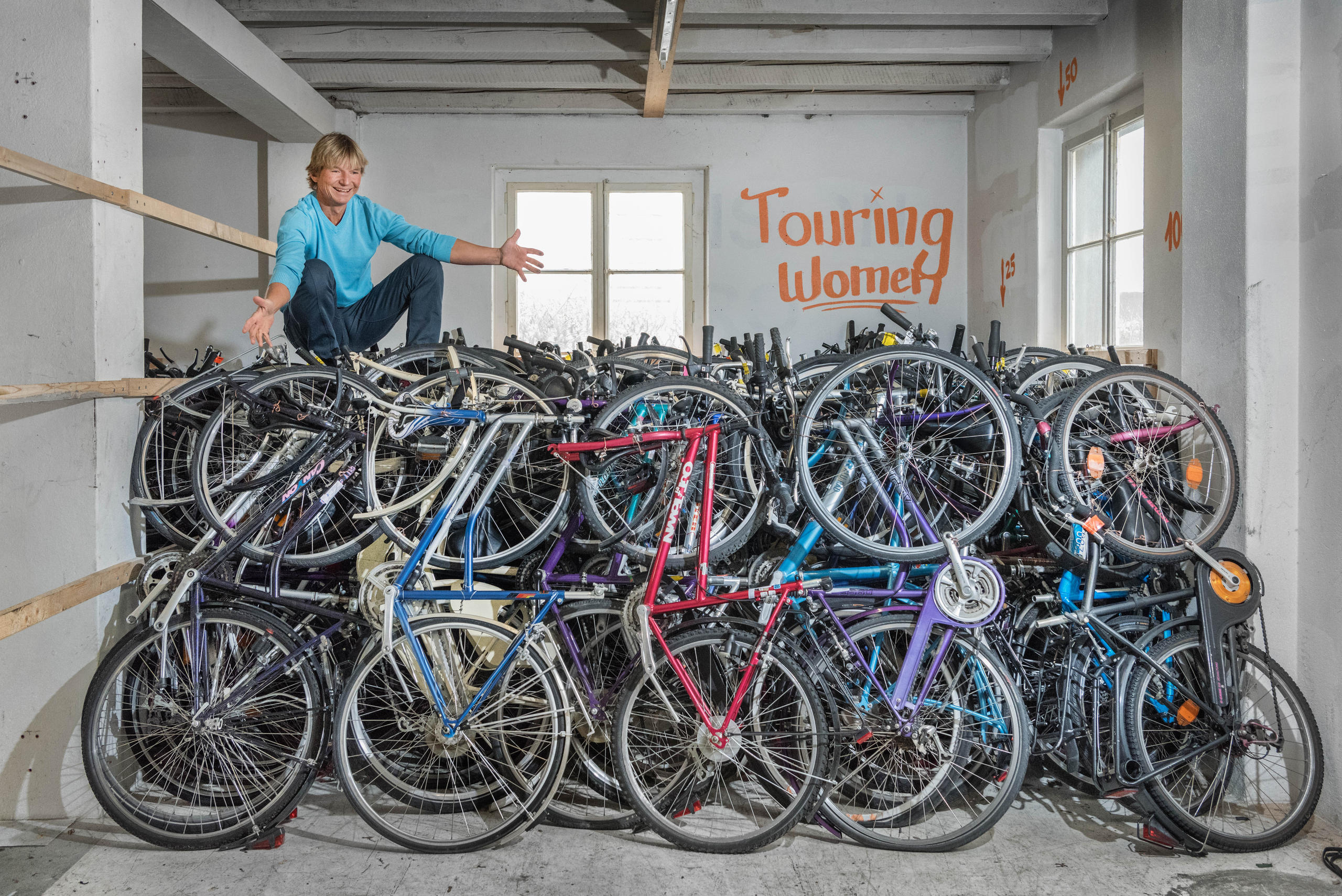 A man sits on top of a pile of bikes