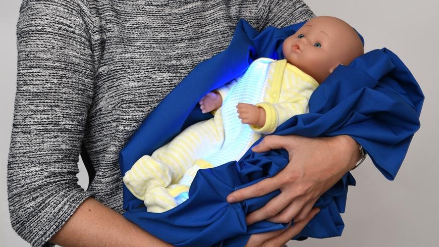 A demonstration piece of EMPA s phototherapy fabric is worn by a doll.