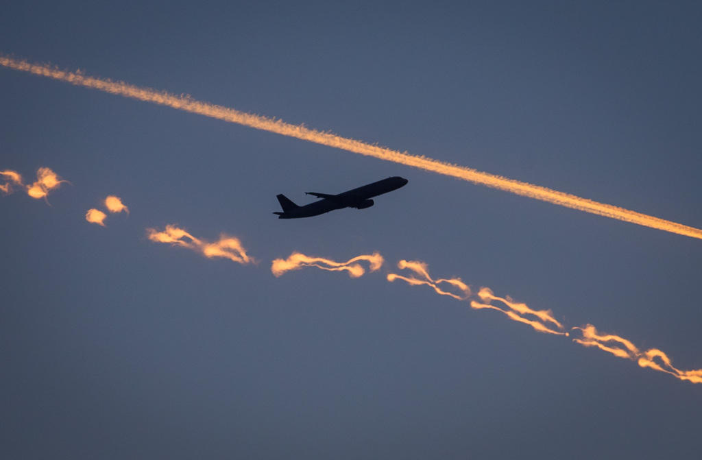 aircraft in evening sky with two contrails