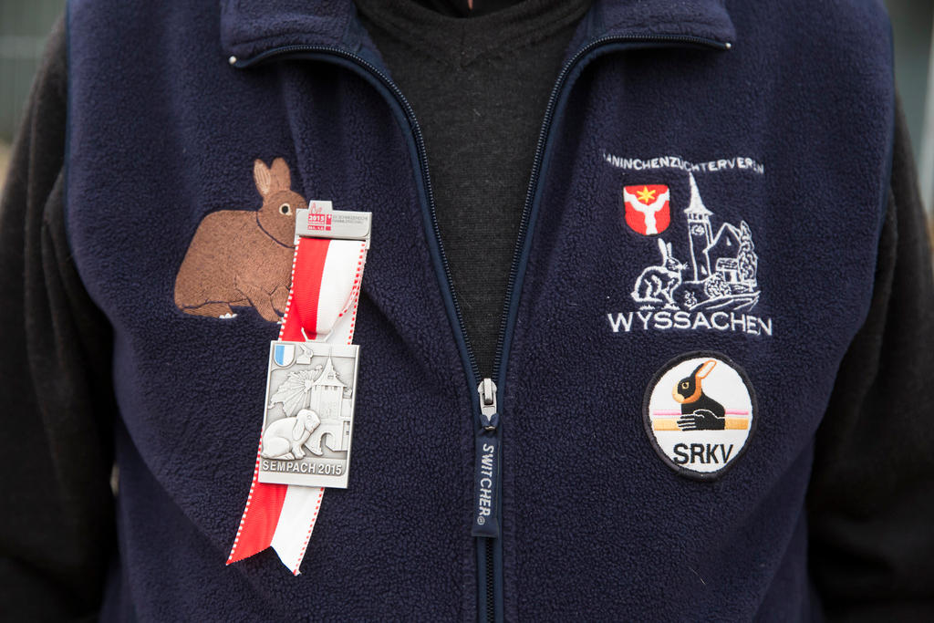 A member of the Wyssachen rabbit breeders club showing off his medal