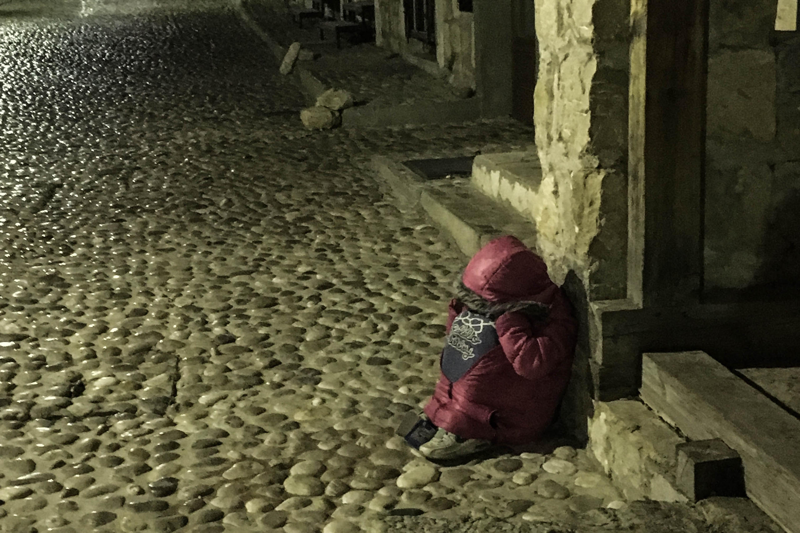 Criança roma sentada na rua