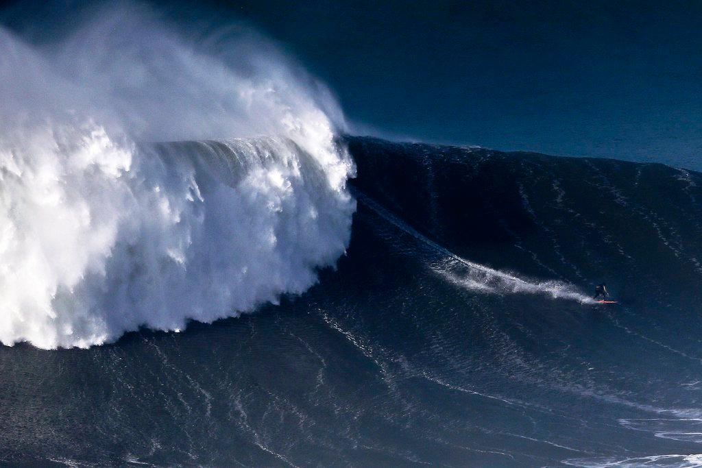 An unidentified surfer rides a giant wave at Praia do Norte in Nazare, Portugal
