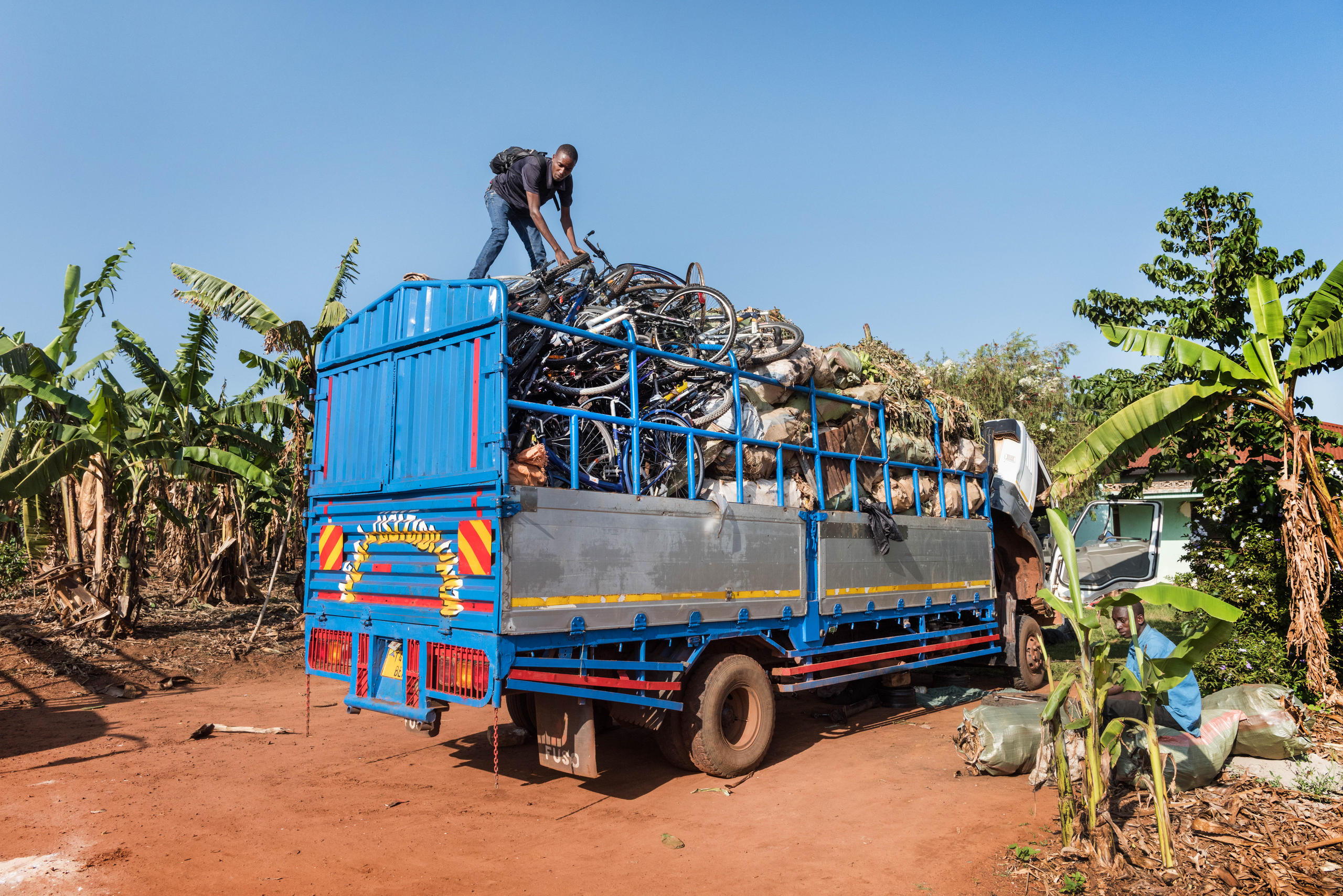 A truck filled with bikes on a dirt road