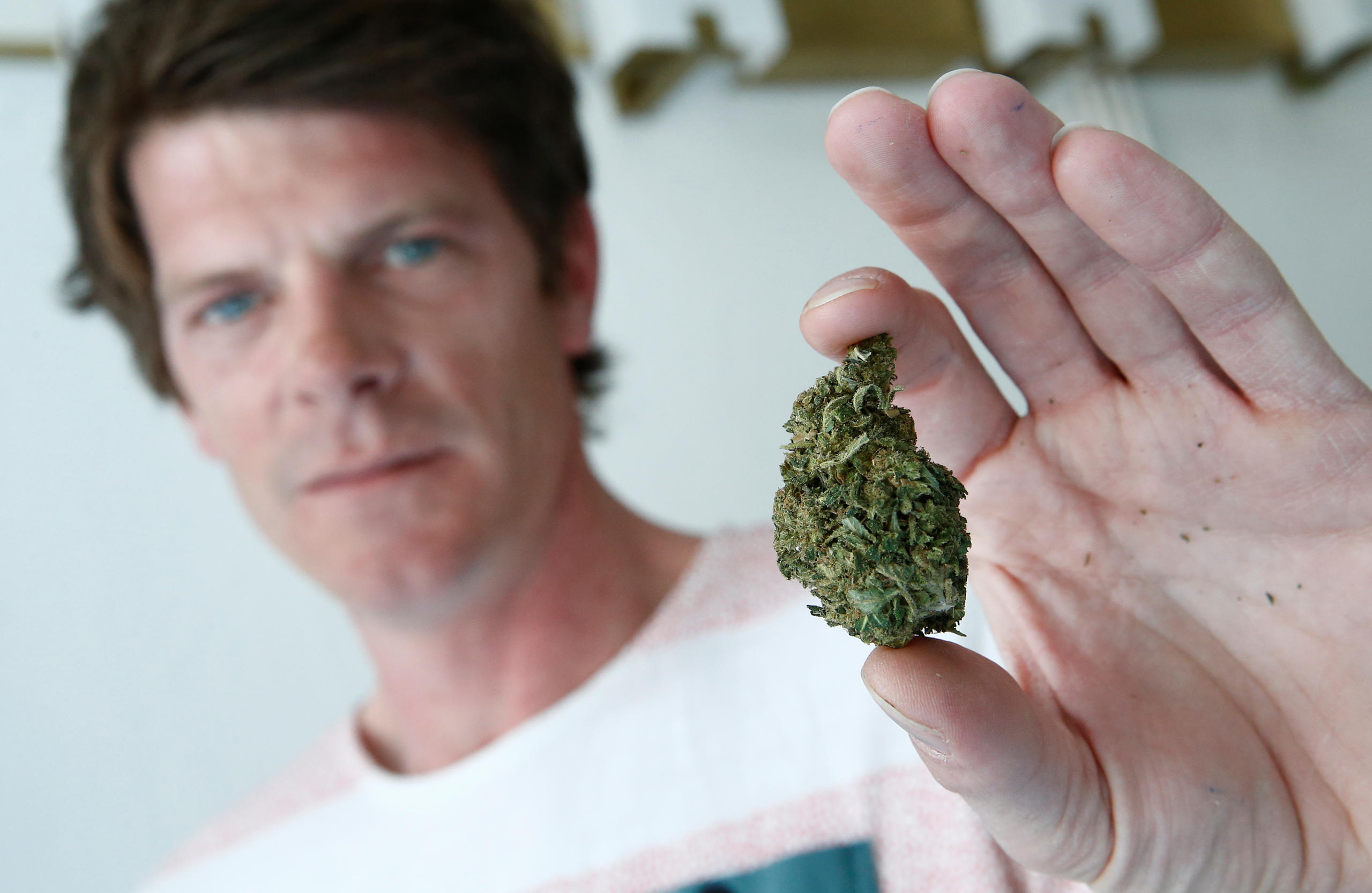Un joven con un trozo de cannabis en la mano