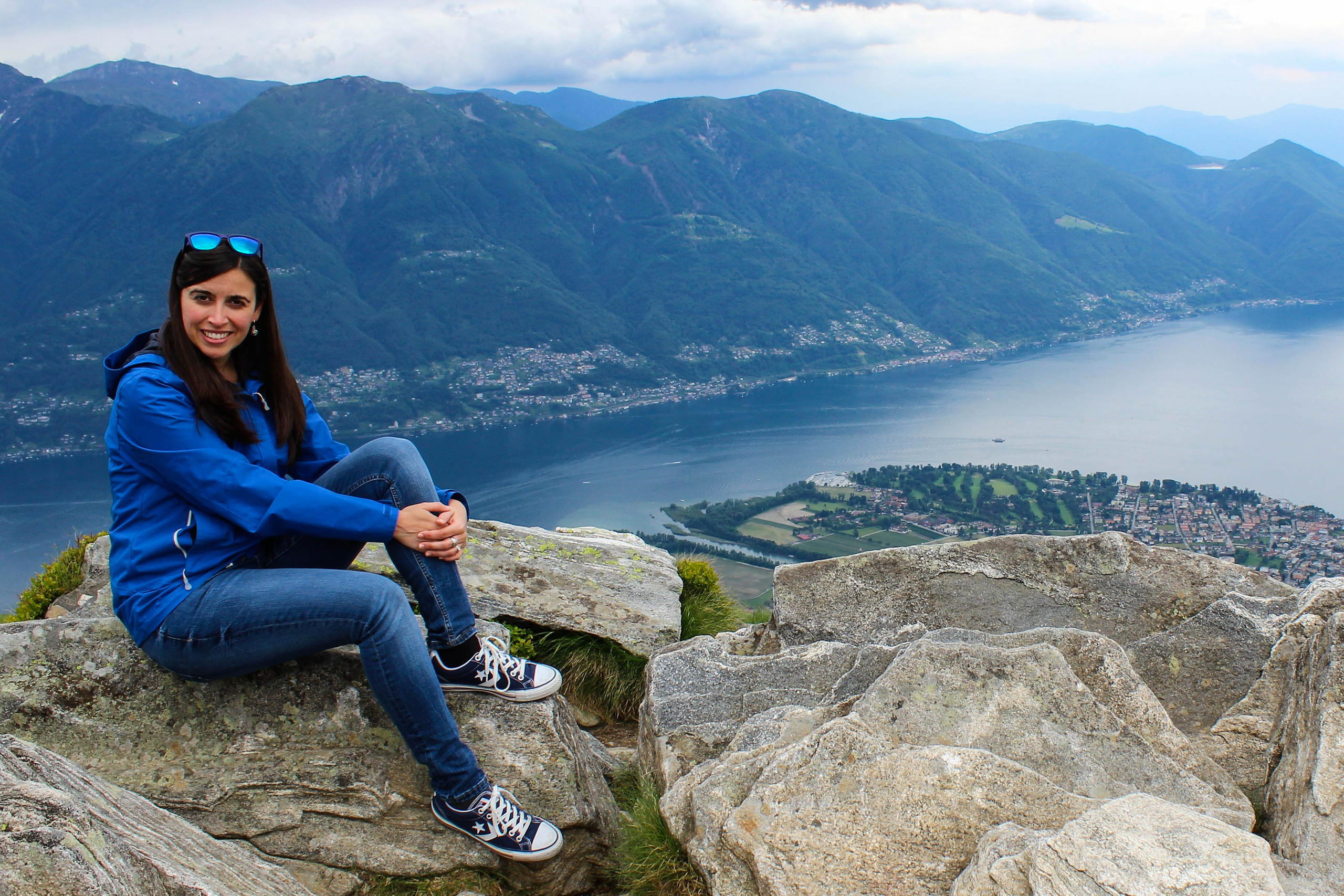 Sara Moreno sentada en una roca con las montañas y el lago al fondo