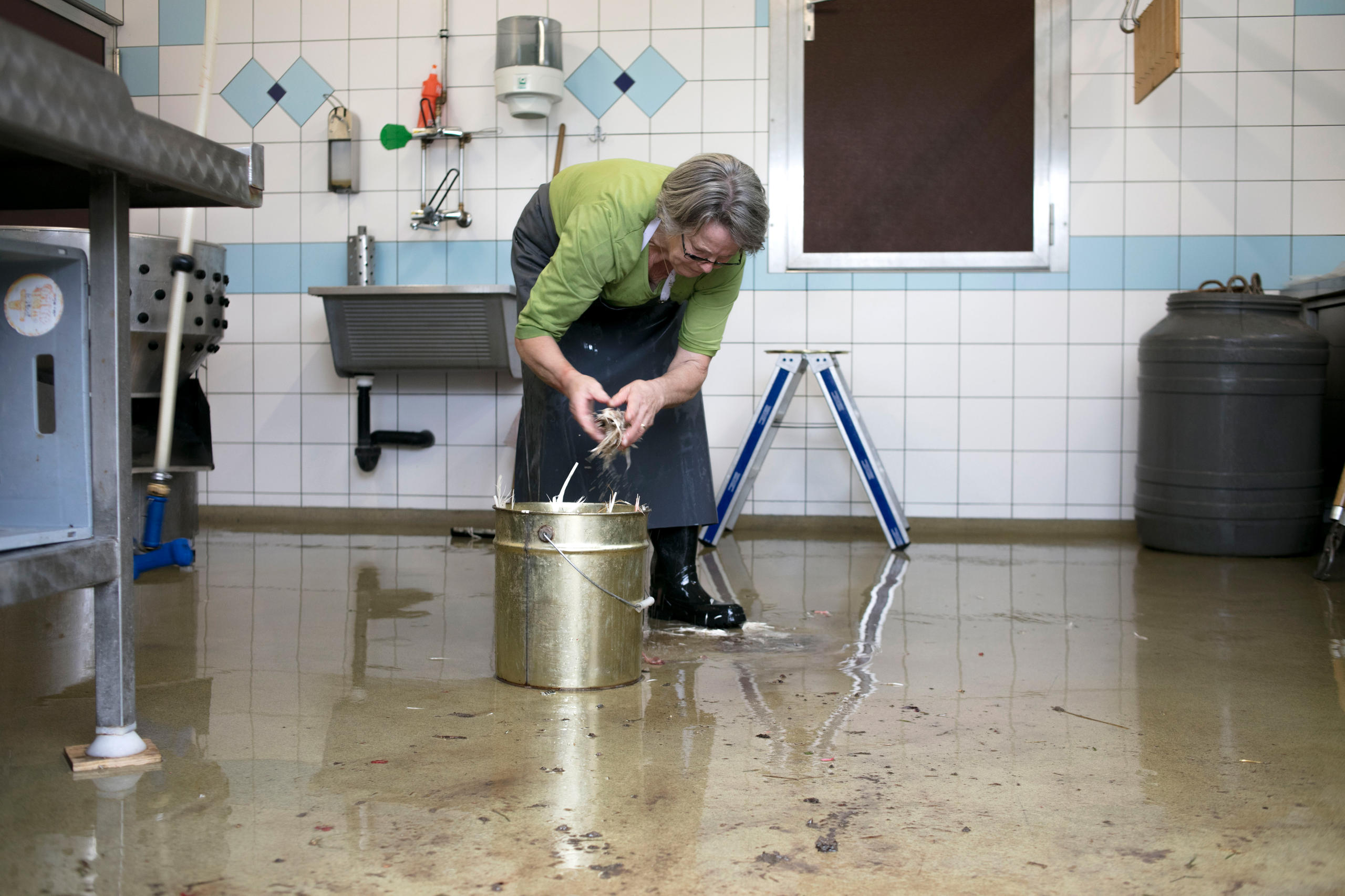 Bäuerin putzt den Boden im Schlachtraum