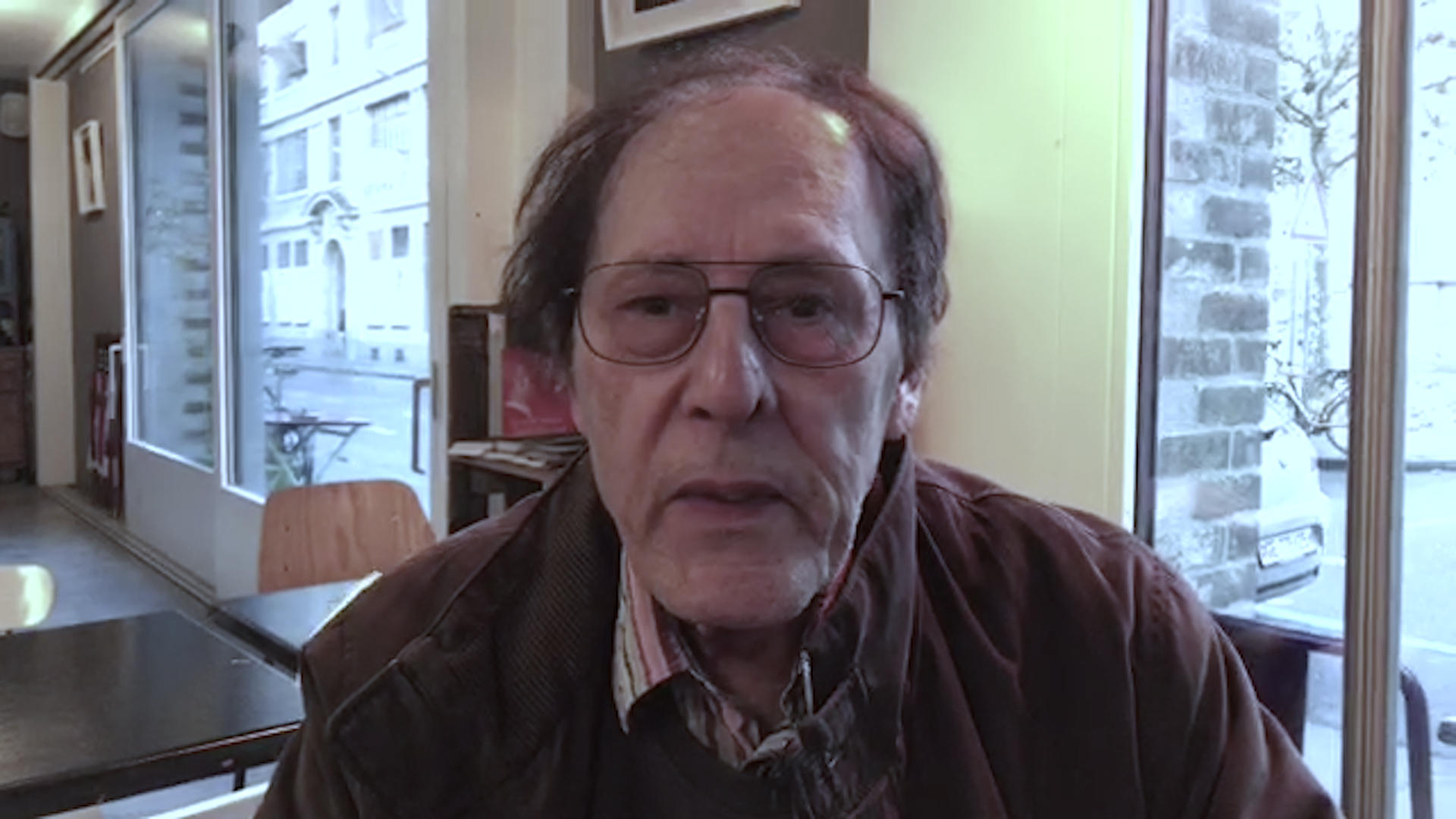 رجل يلبس نظارات ينظر الى الكاميرا