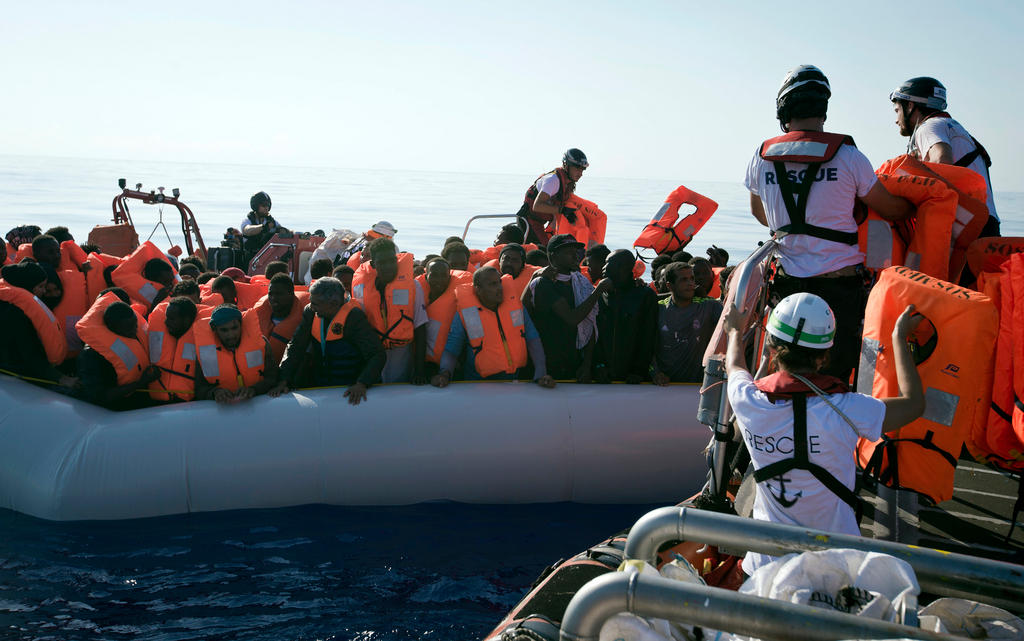 Rescuers deliver life vest to African migrants at sea off the coast of Libya