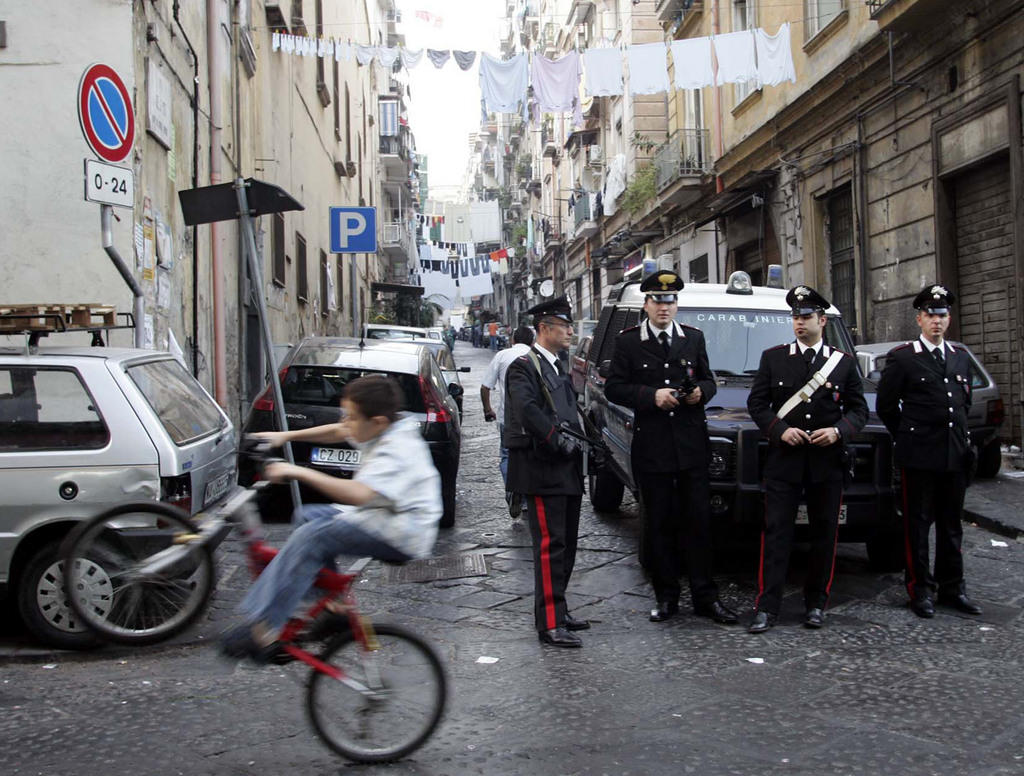 pattuglia di carabinieri a Napoli, con in primo piano un bambino in bicicletta