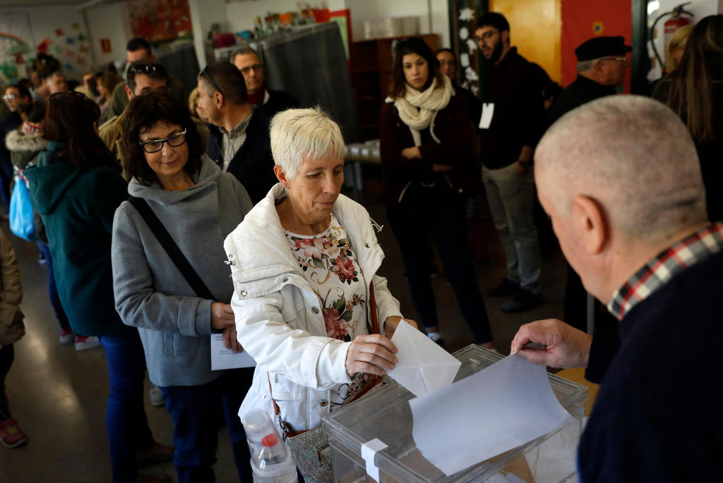 Una donna pone nell urna la scheda di voto in un immagine scattata in un seggio elettorale in Catalogna.