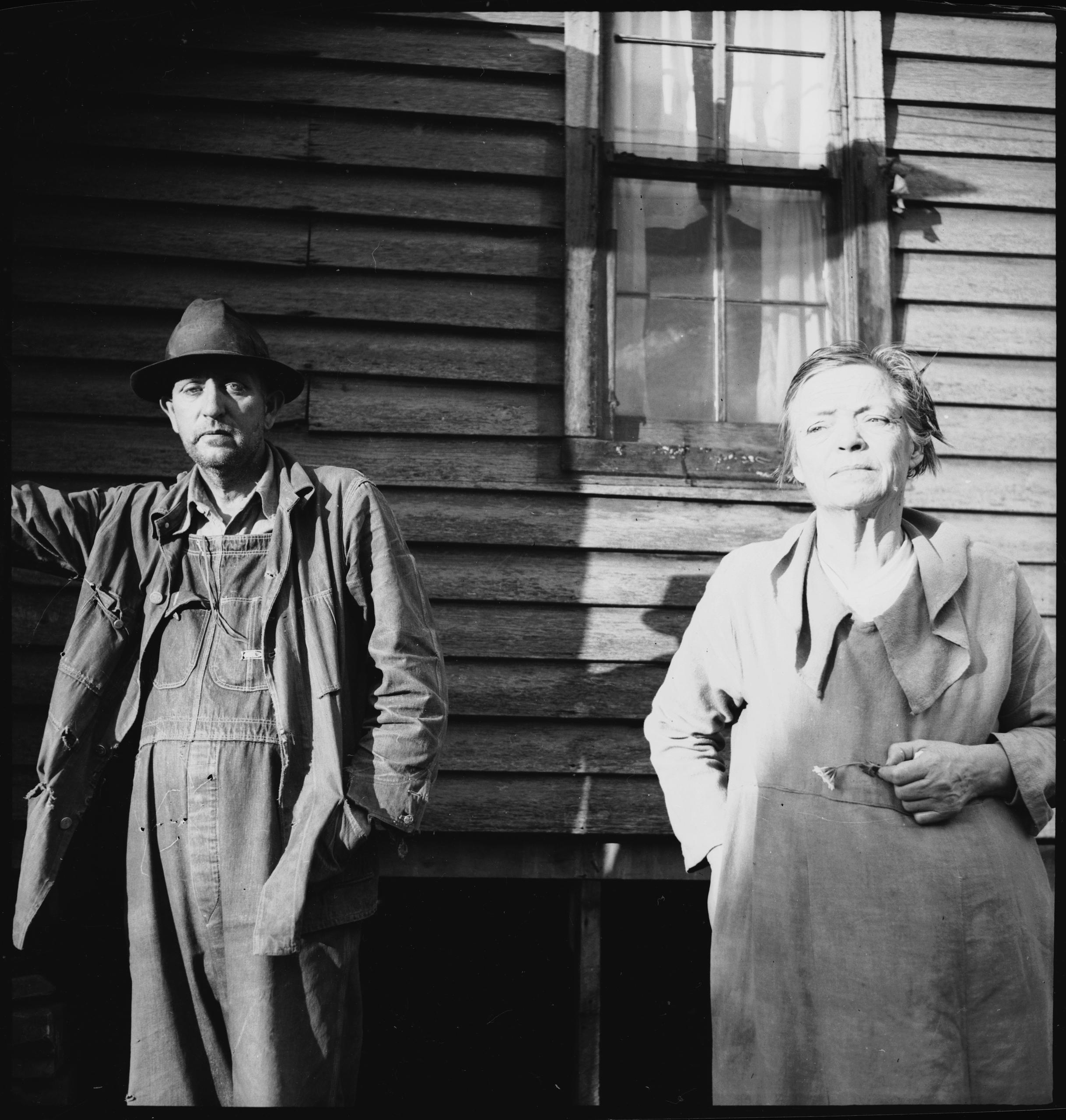 мужчина и женщина на фоне деревянного дома
