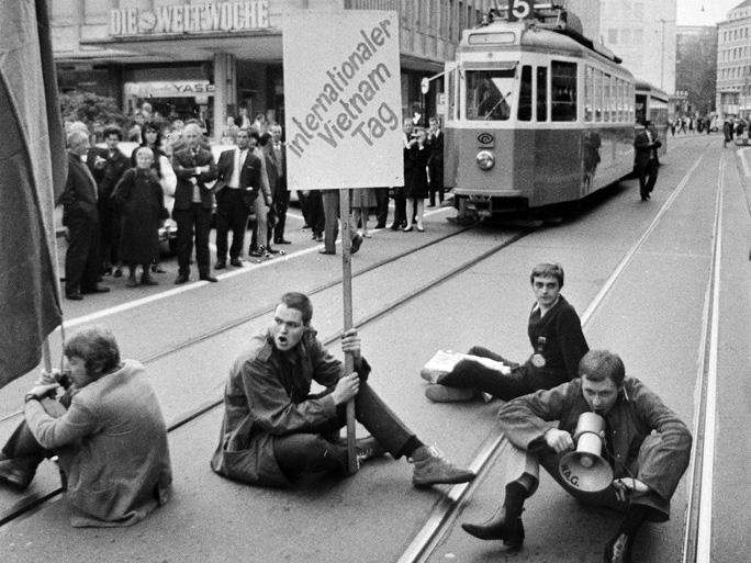 studenti seduti per strada lungo i binari del tram