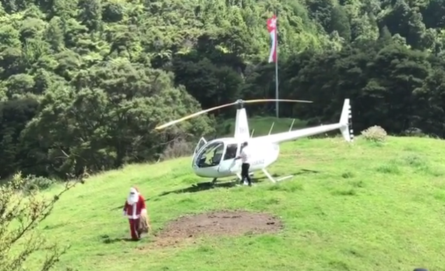 Ein Samichlaus, der aus einem Helikopter gestiegen ist, läuft über eine Alpwiese in Neuseeland