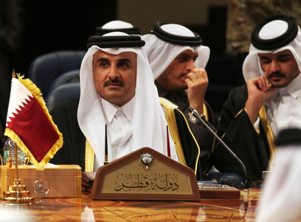 ثلاثة رجال بلباس خليجي من بينهم أمير قطر