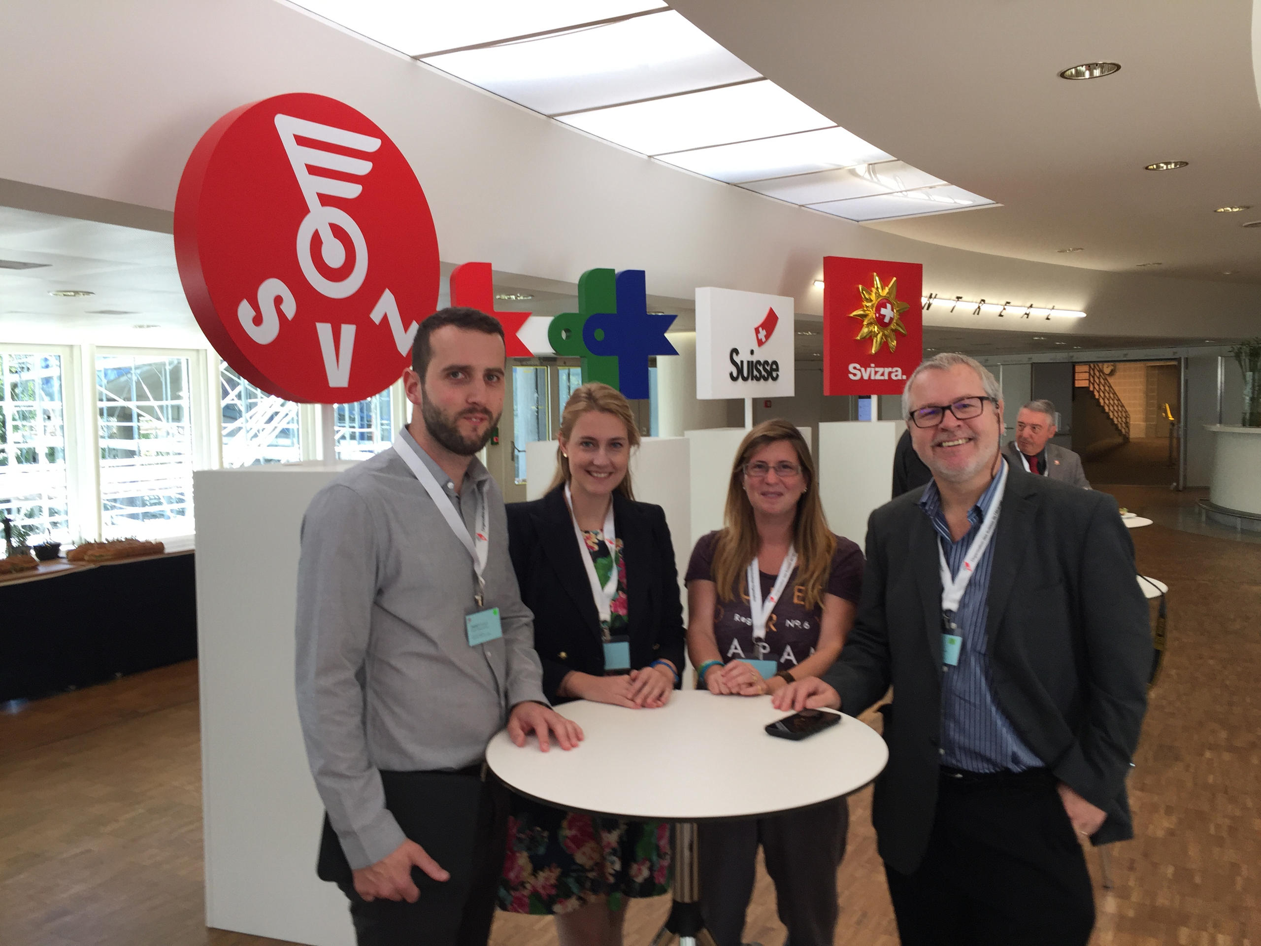 Four people stand around a table