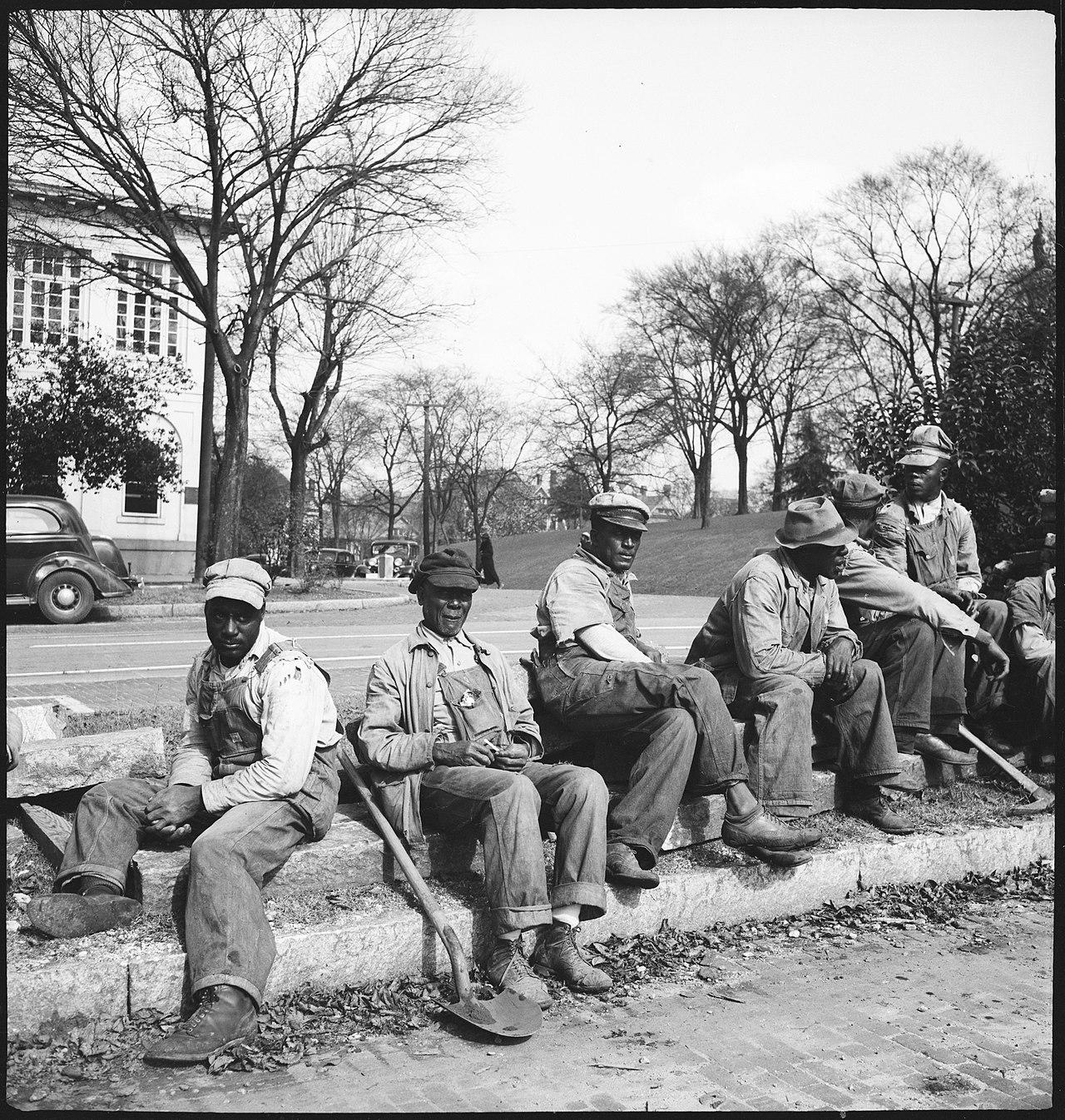 чернокожие мужчины с рабочими инструментами сидя отдыхают