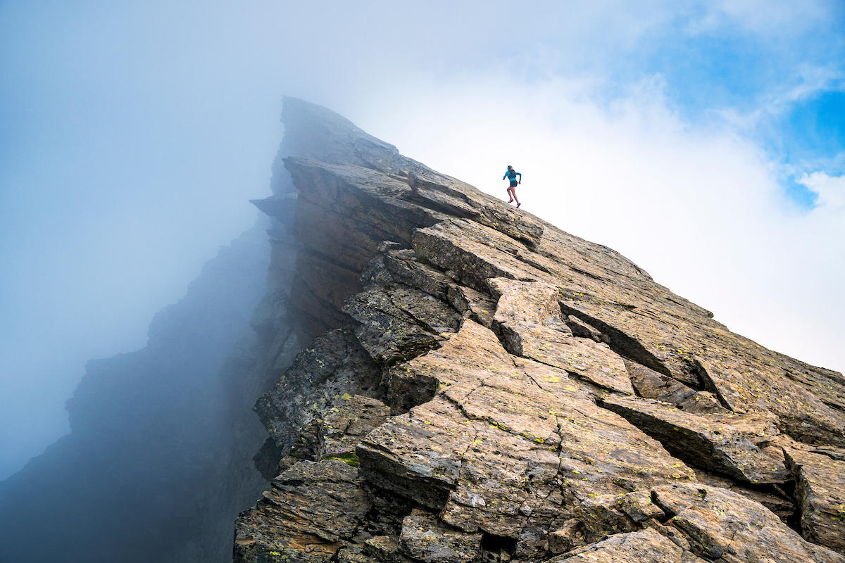 Runner runs up a rocky mountain slope