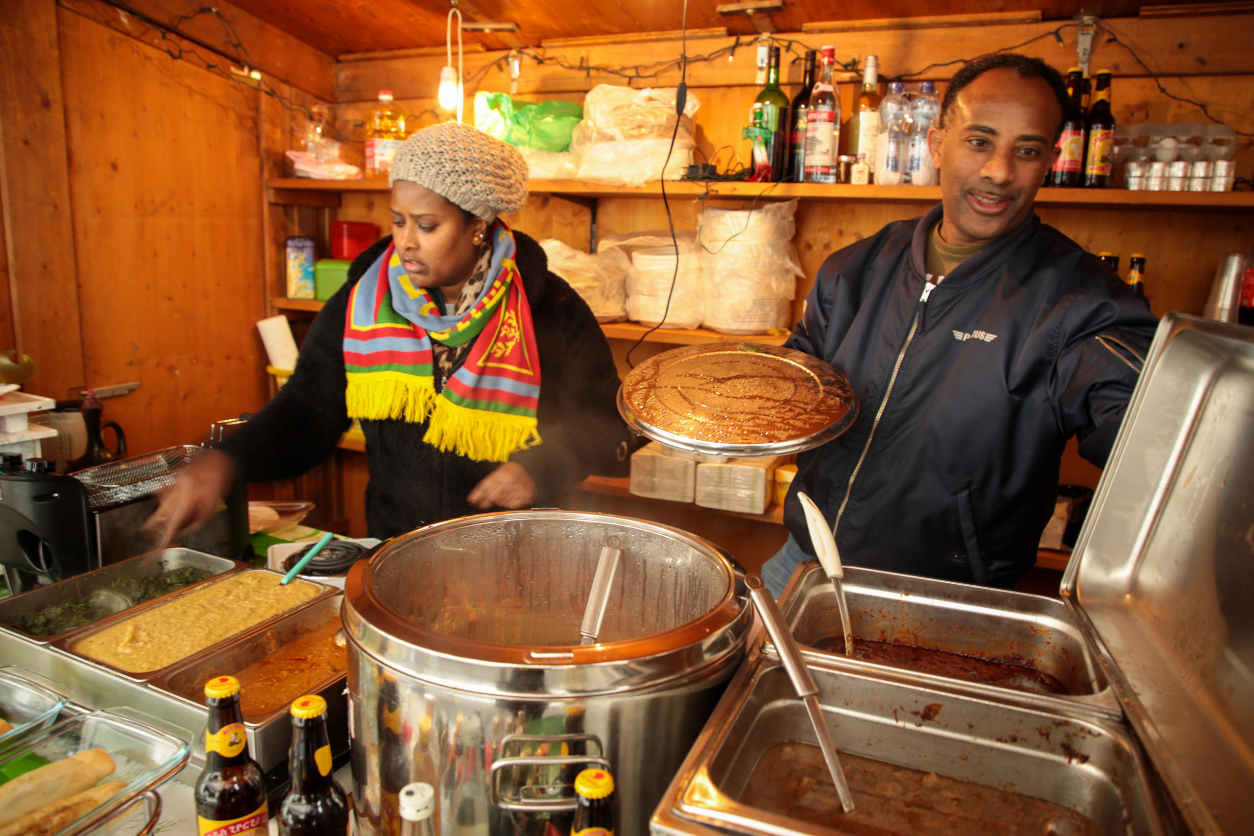 мужчина и женщина сервируют эритрейскую еду