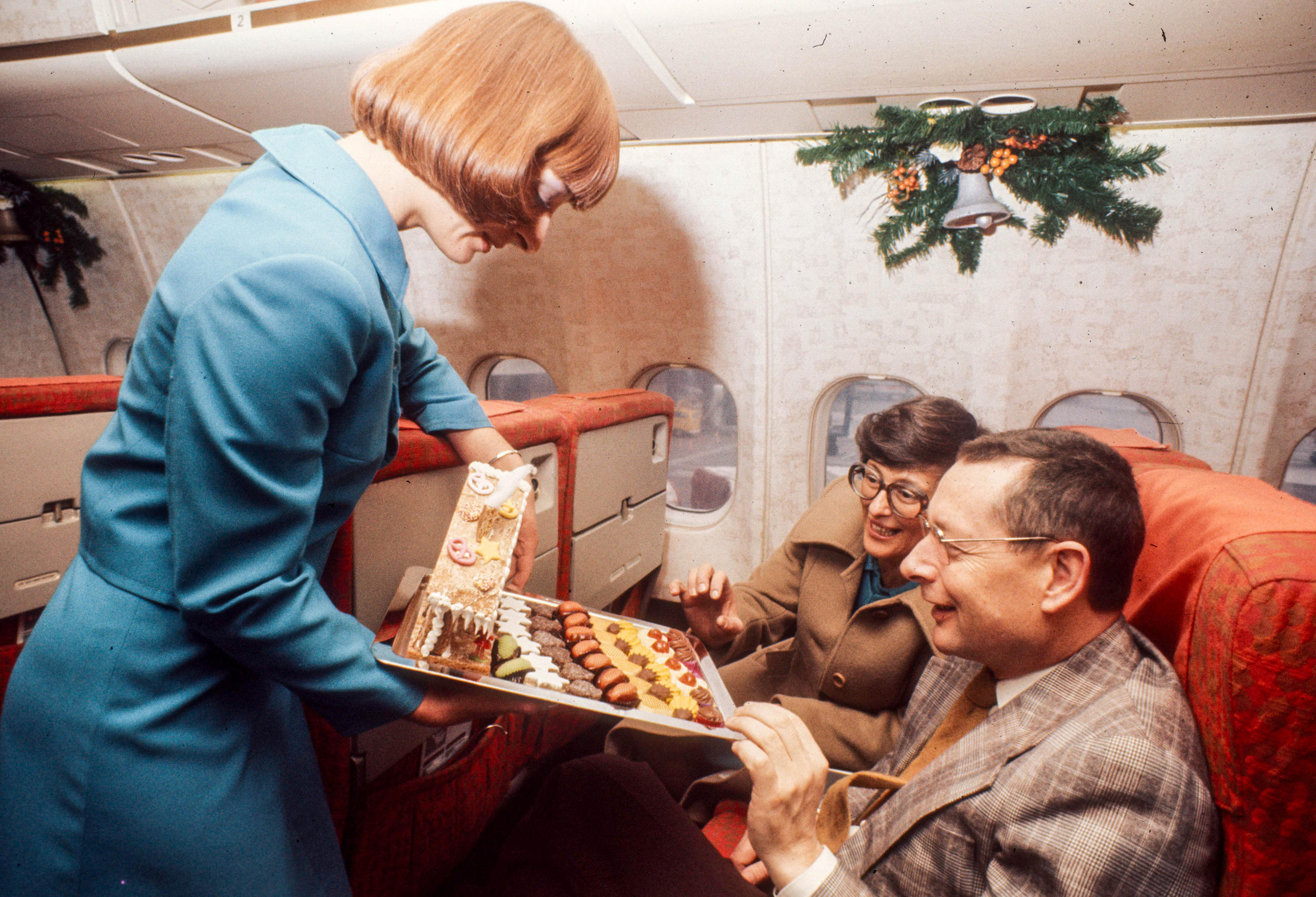 Flight attendant serving cookies on a plane