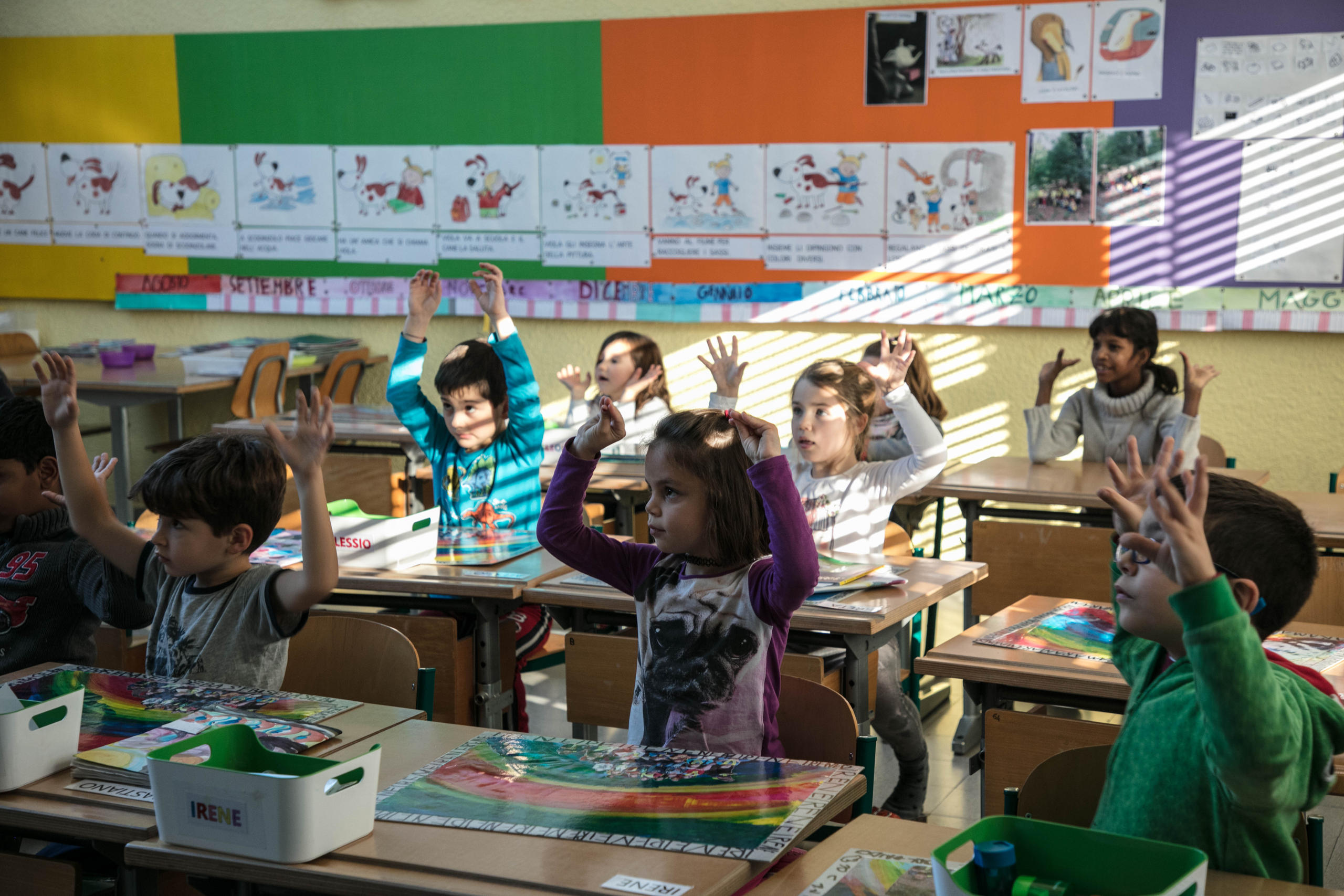 Classe di allievi che alzano le mani