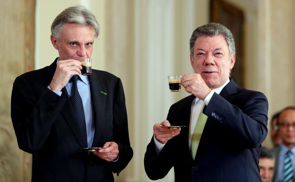 President of Colombia Juan Manuel Santos drinks a coffee with the CEO of Nespresso, Jean-Marc Duvoisin