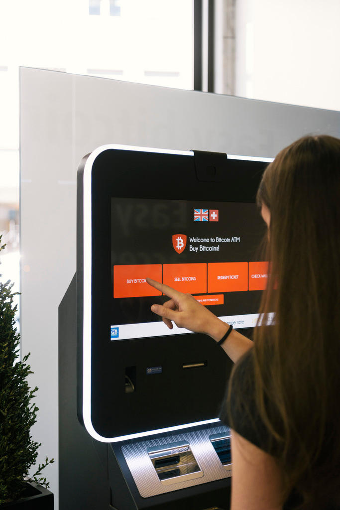 A woman buys bitcoin from an atm in Switzerland