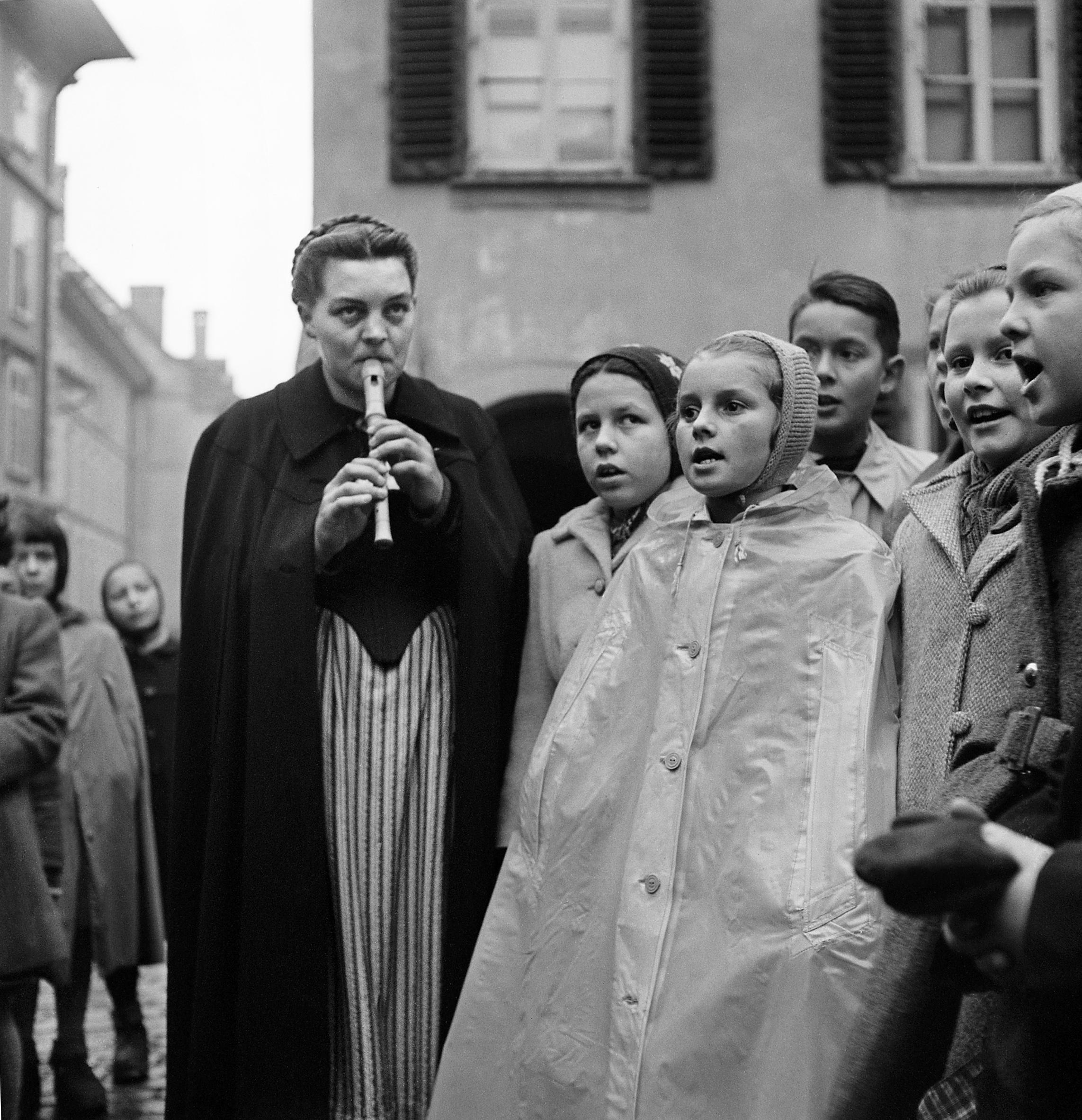 una donna suona il flauto con un coro di bambini