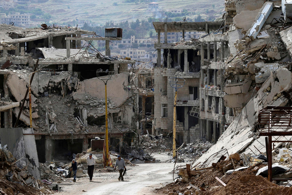 three people in bombed out town