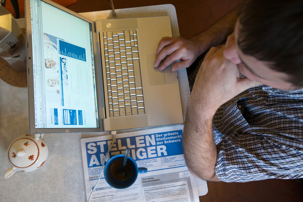 Man looking at job adverts on a laptop