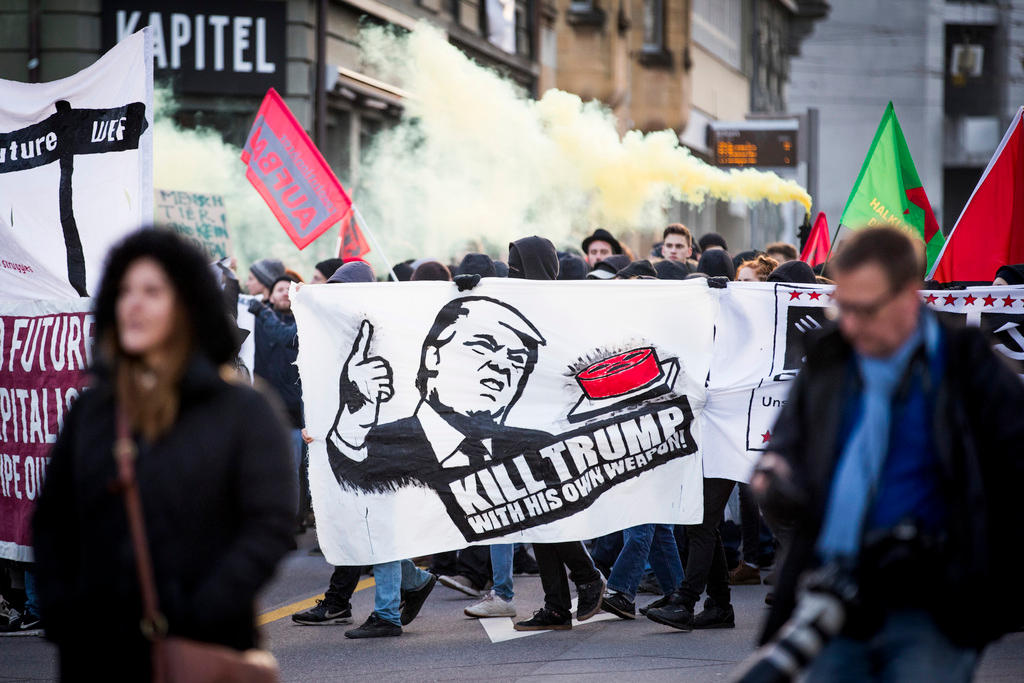 Protesters carry a sign reading kill Trump with his own weapons