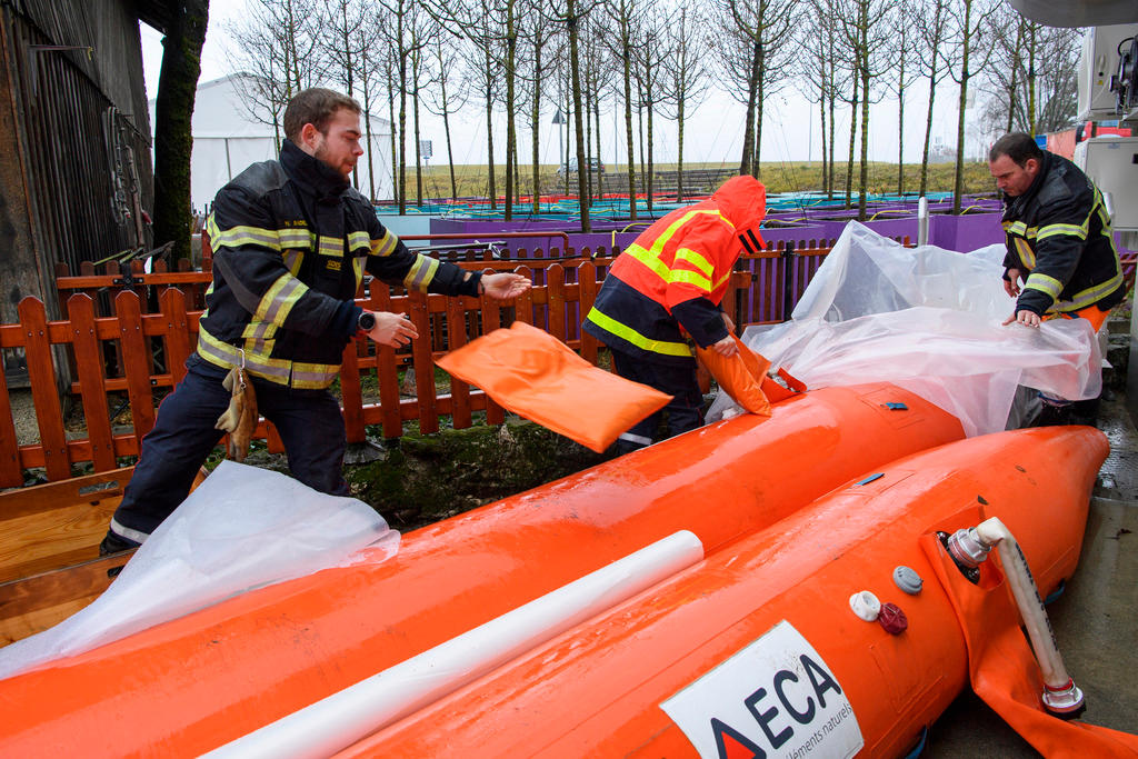 Bombeiros do serviço de emergência na região do Lago de Genebra enchem tubos de borracha para impedir inundações