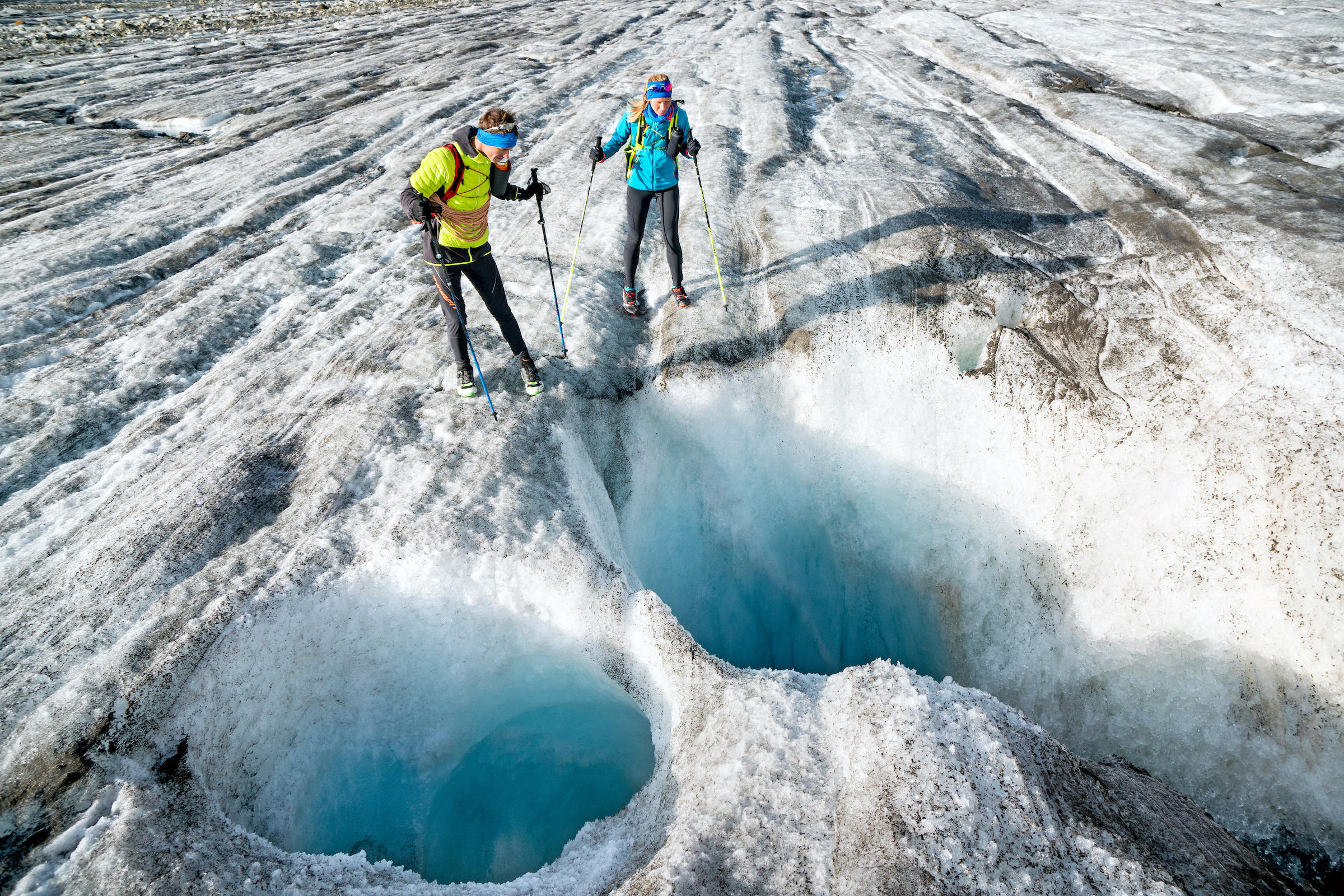 Runners look down into glacier moulins