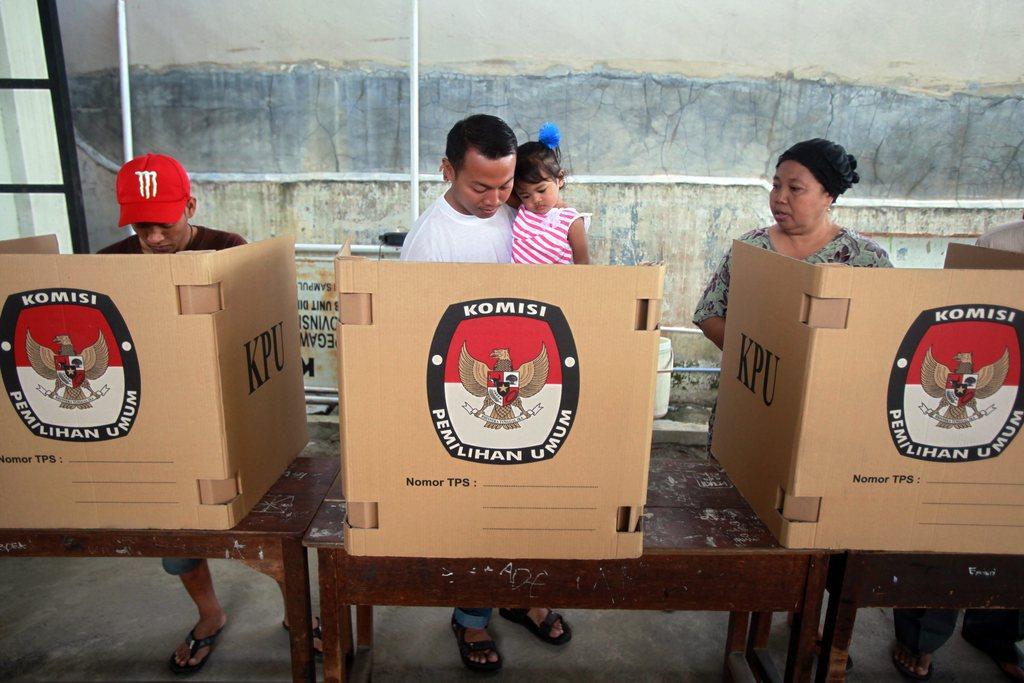 three people and ballot boxes