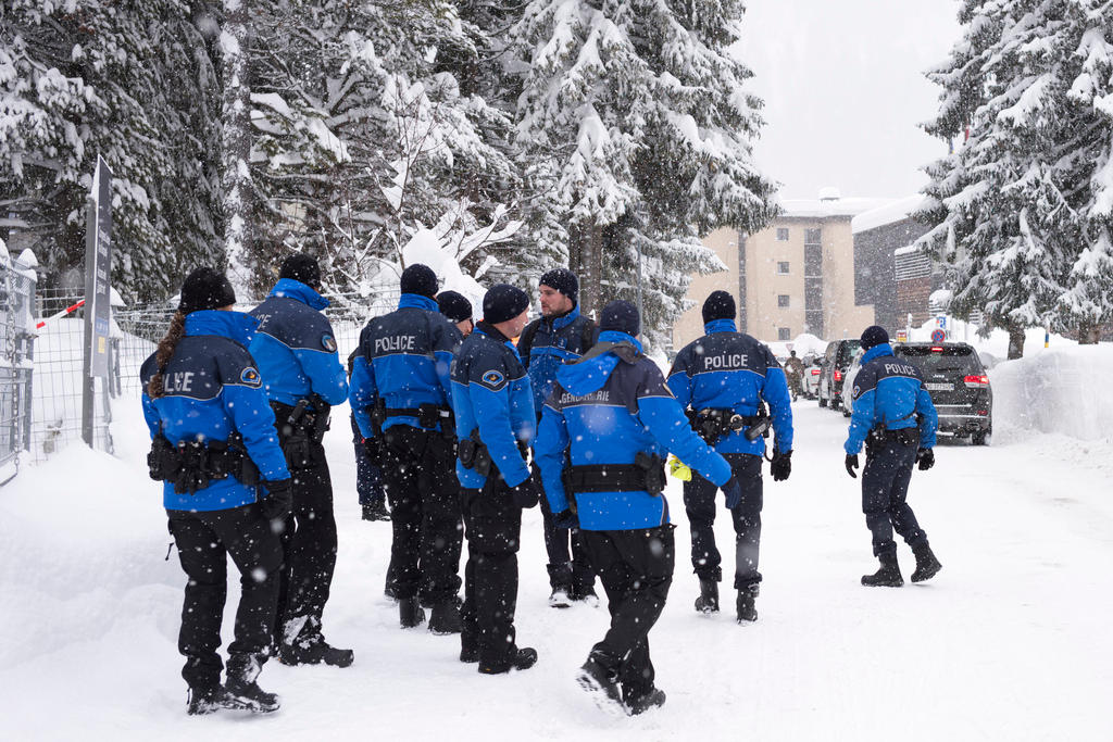 blue-clad police on snow-covered road