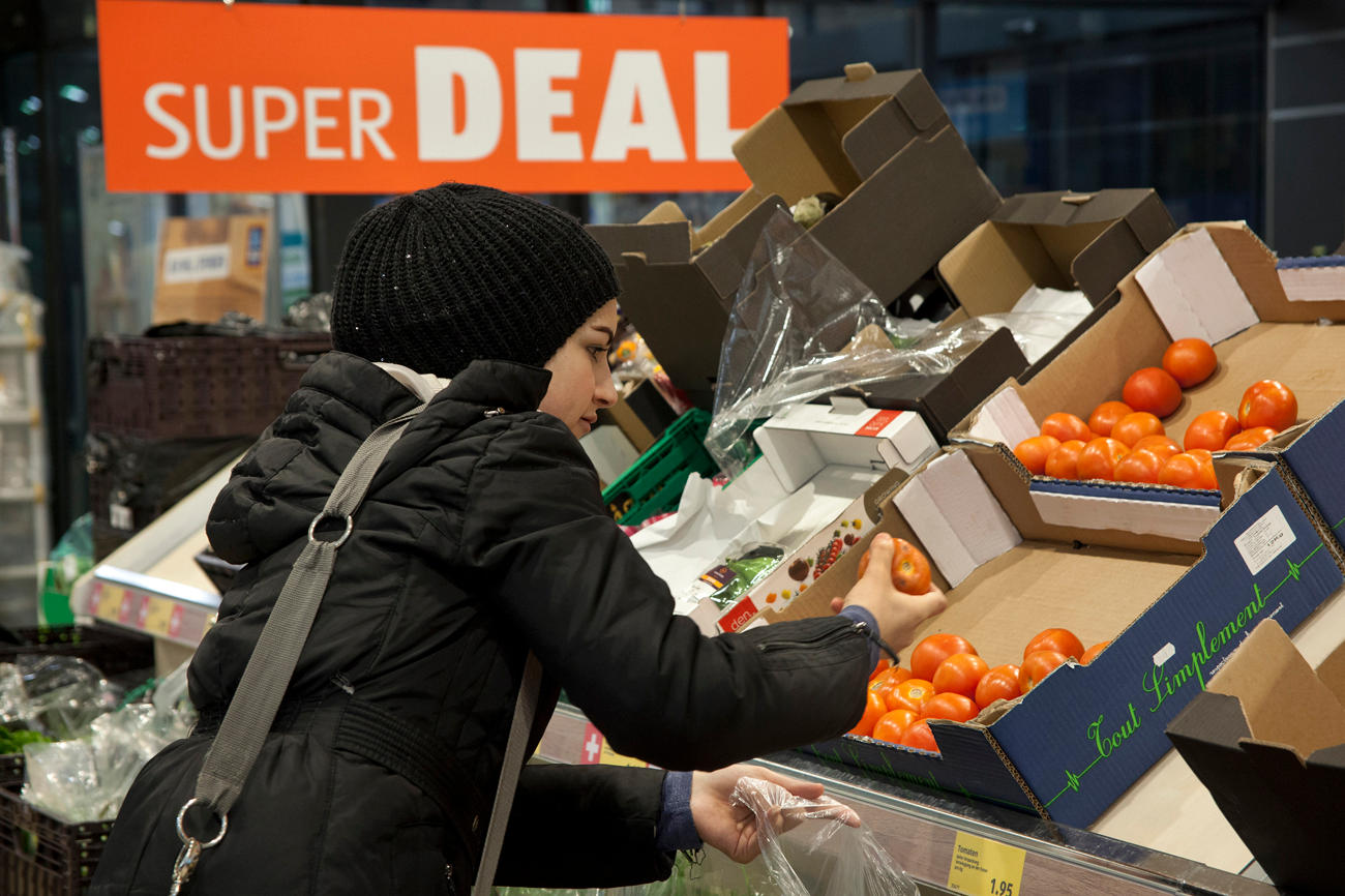 una donna sceglie della frutta in un negozio