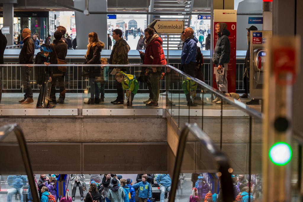 Menschen, die im Bahnhof Bern zum Abstimmen anstehen