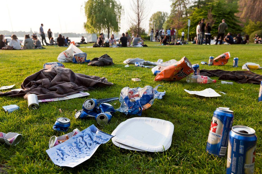 A street sweeper brush moves over a beer can on a Zurich street