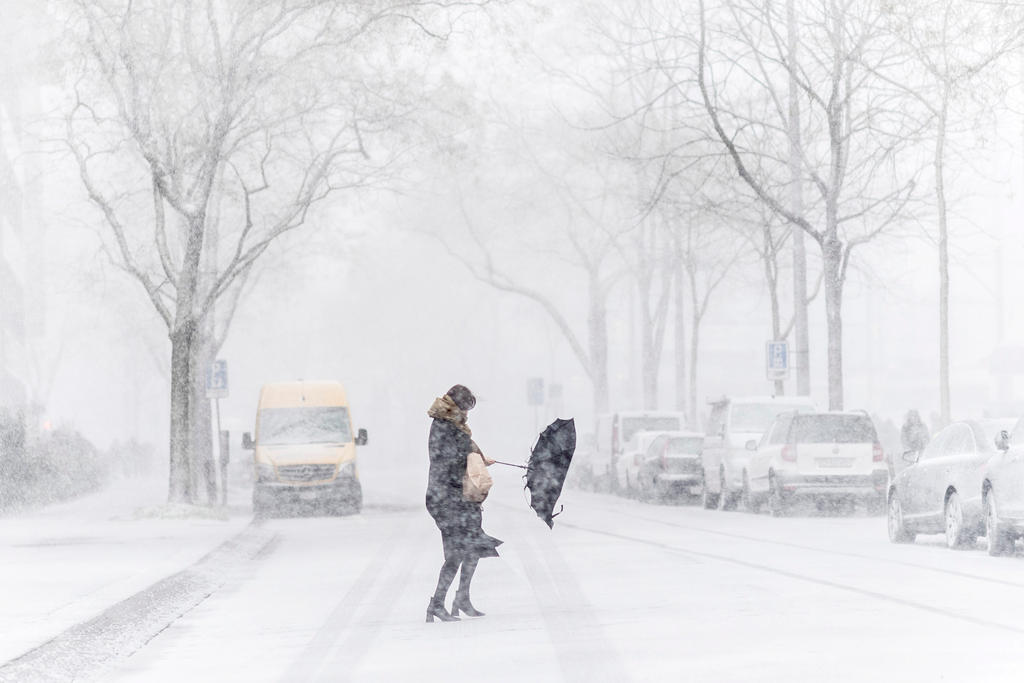 Woman crosses road in snow storm
