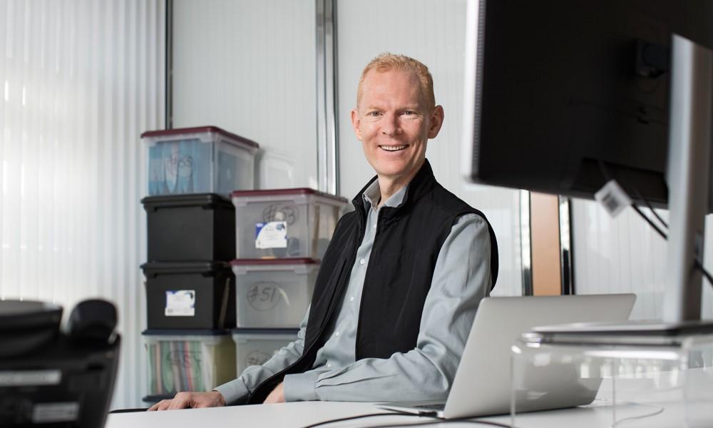 Johann Gevers smiles behind a desk