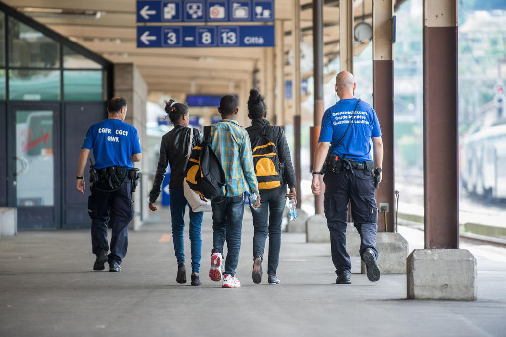 Grenzwächter begleiten drei jungen Migranten im Bahnhof von Chiasso