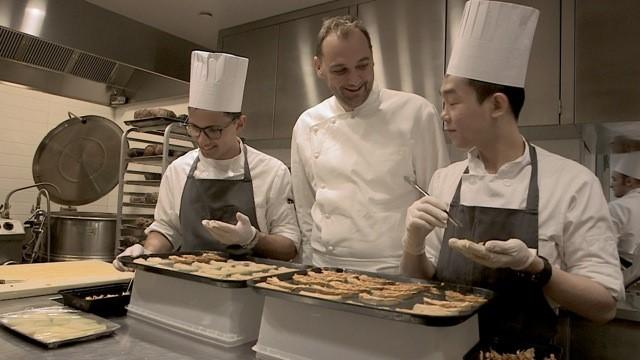 Lo chef Daniel Humm attorniato da due collaboratori al lavoro