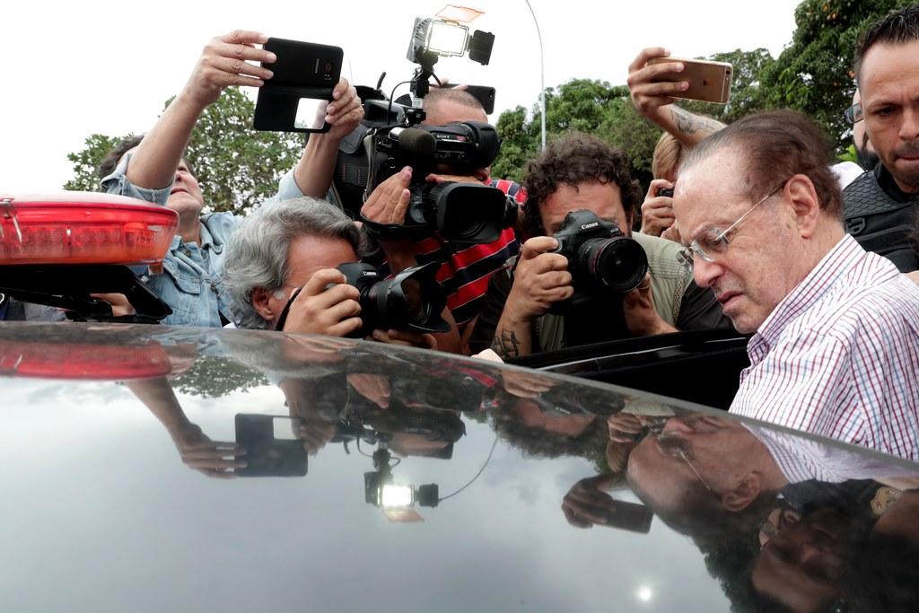 Jornalistas e fotógrafos ao lado de um ex-político brasileiro