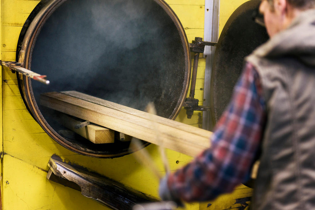 Trabalhador colocando a madeira no forno